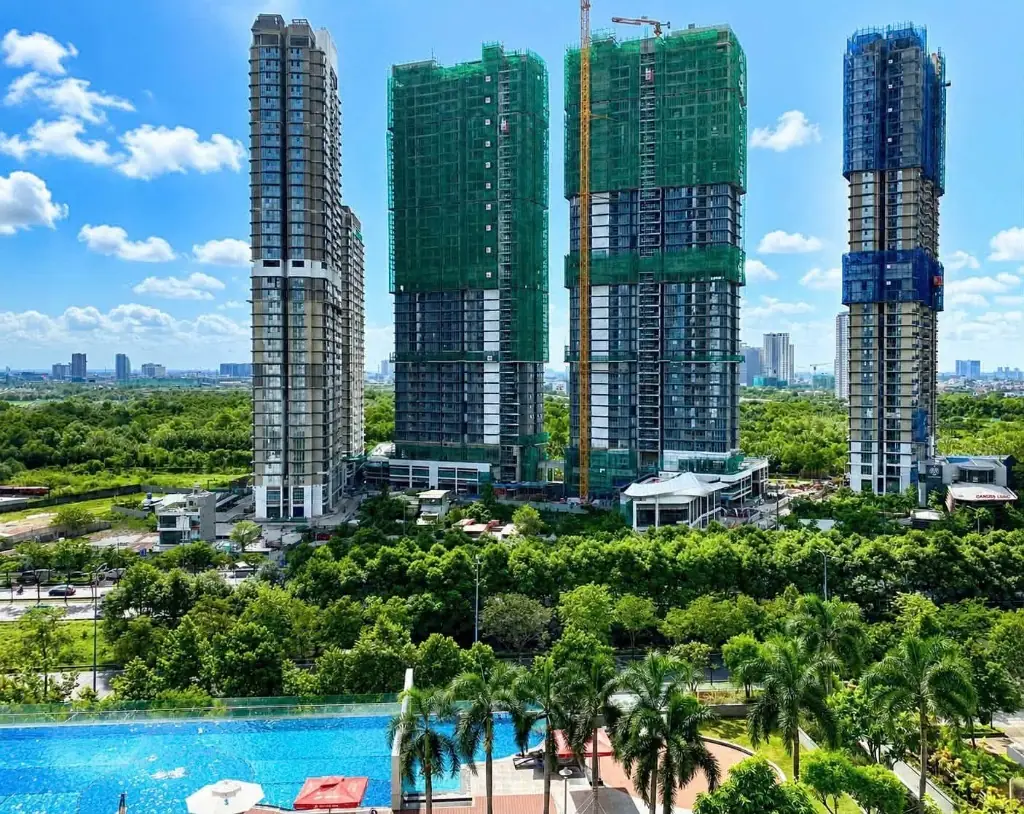 Các tháp Eaton Park đang thi công, chụp qua một hồ bơi phía trước