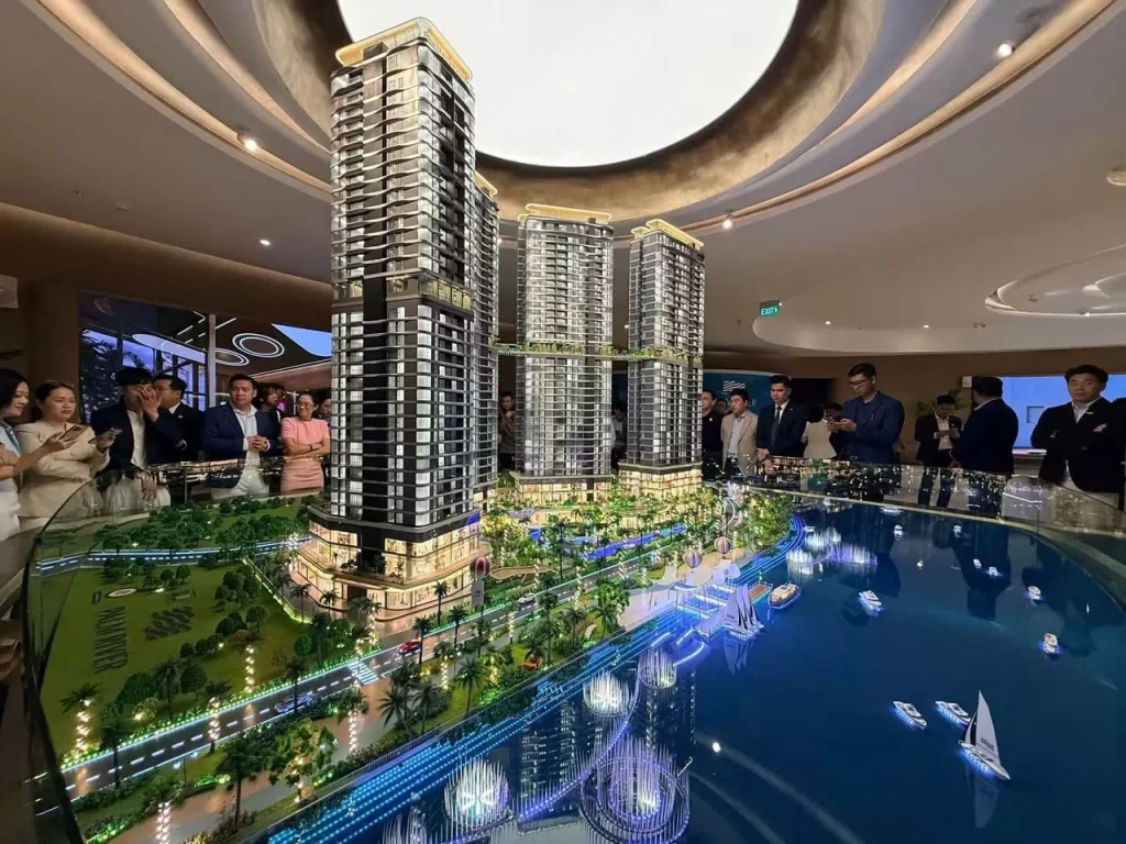 Khách đứng quanh sa bàn nhà mẫu Palm River ngày khai trương