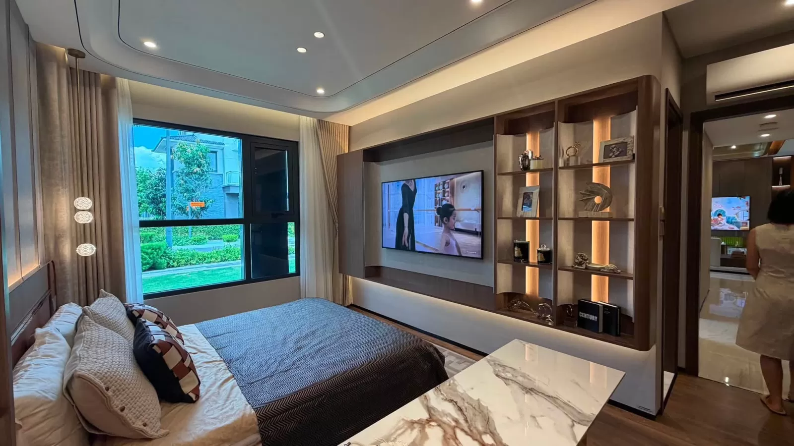 Phòng ngủ trong nhà mẫu Gladia Heights với hệ kệ trang trí và tivi