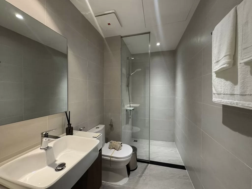 Phòng tắm nhà mẫu Elysian căn 3PN: lavabo, bồn cầu, cabin kính