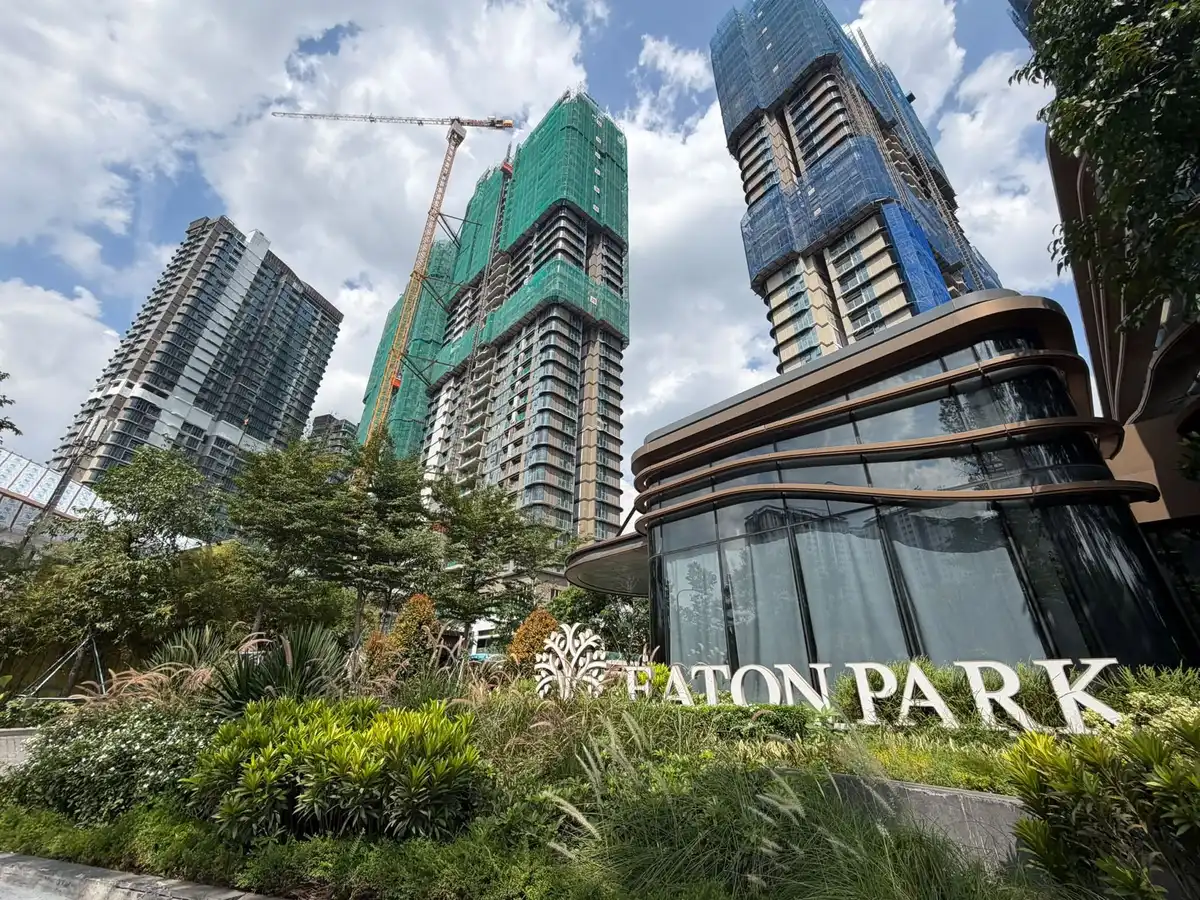 Khối đế mái cong và bảng chữ Eaton Park trong khu cây xanh, các tháp phía sau