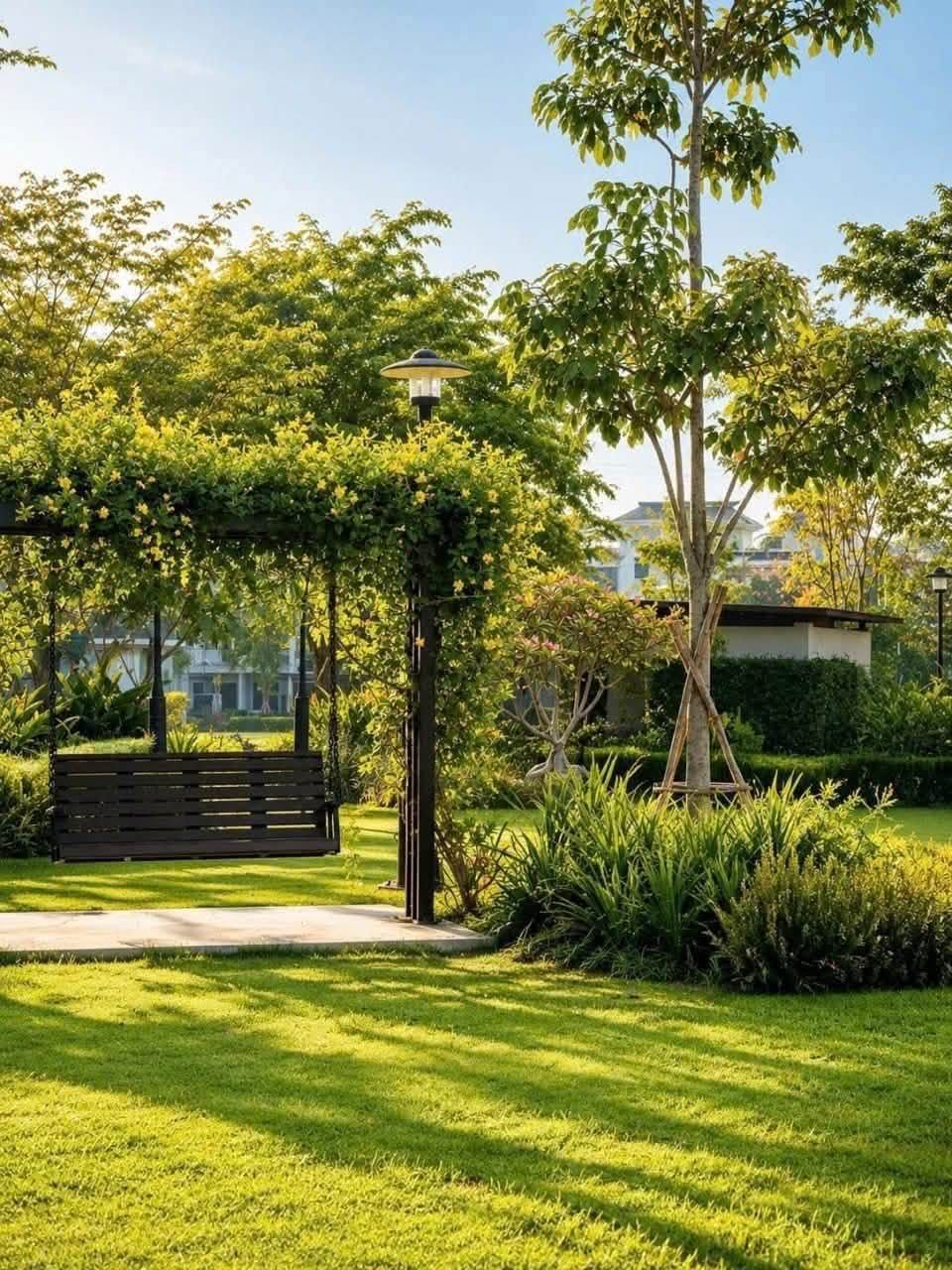 Ghế xích đu thư giãn rợp bóng mát giàn hoa leo trong công viên Gladia Heights