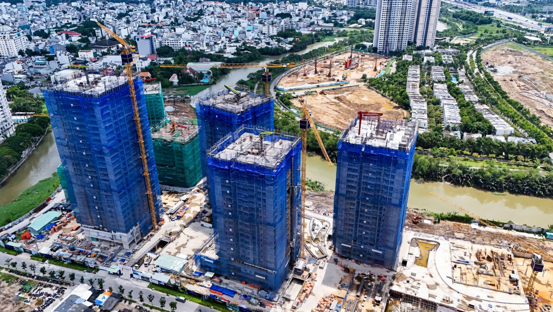 Dãy tháp căn hộ The Privé đang thi công vươn cao tầng 28 dọc bờ sông tháng 9/2026
