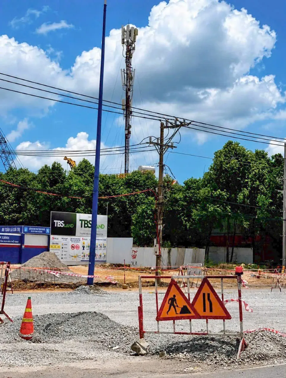 Vị trí Norton Park: Biển báo công trường và đá dăm tập kết bên Quốc lộ 13 khu vực Thuận An