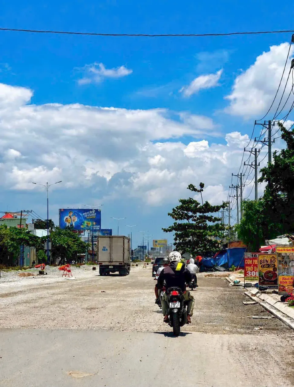 Norton Park: Xe máy và xe tải lưu thông trên đoạn Quốc lộ 13 đang thi công gần dự án